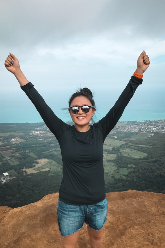 Woman Celebrates Victory on Scenic Cliff