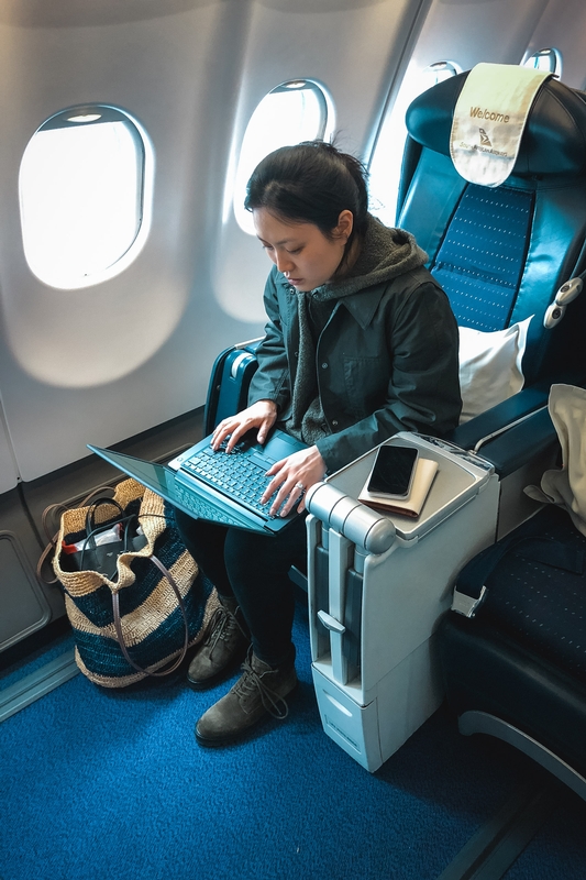 Woman Working on Airplane Laptop