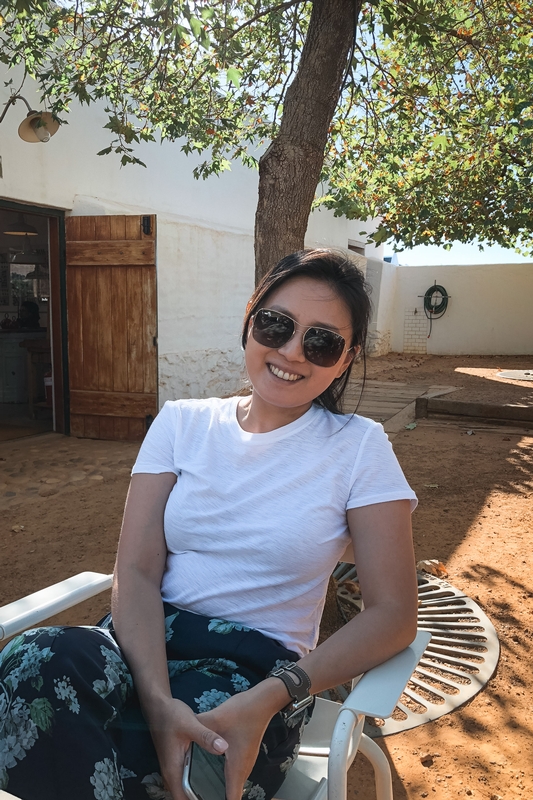 Woman Relaxing in Whitewashed Courtyard