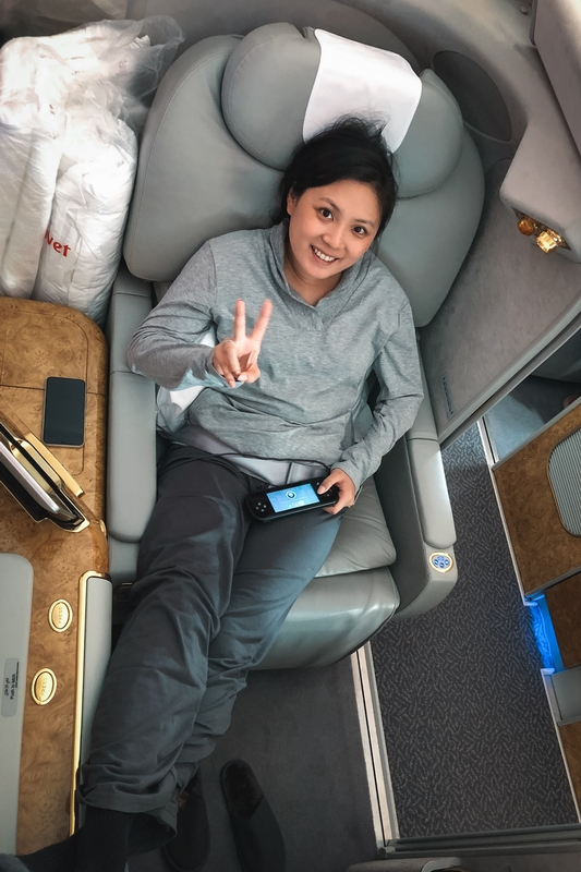 Woman Making Peace Sign in Airplane Seat