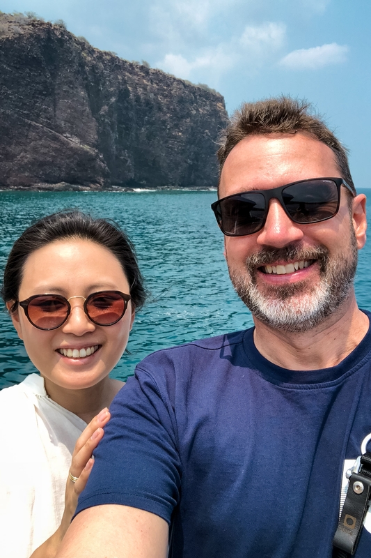 Couple Smiling Before Turquoise Ocean Cliffs