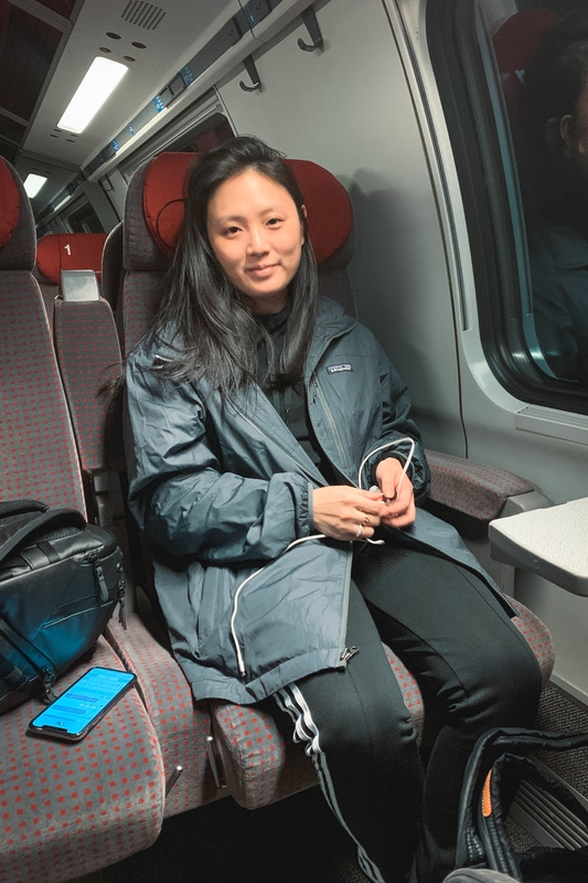 Woman With Earbuds on Modern Train