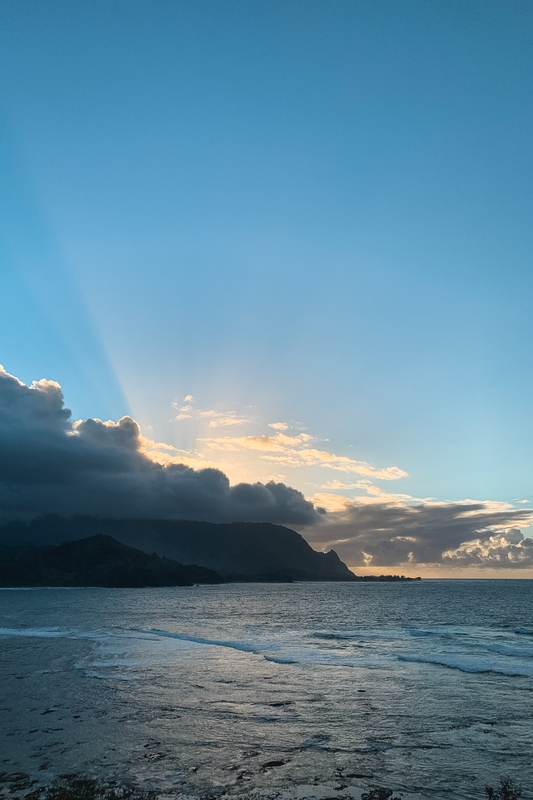Sunlight Breaking Over Volcanic Coastline