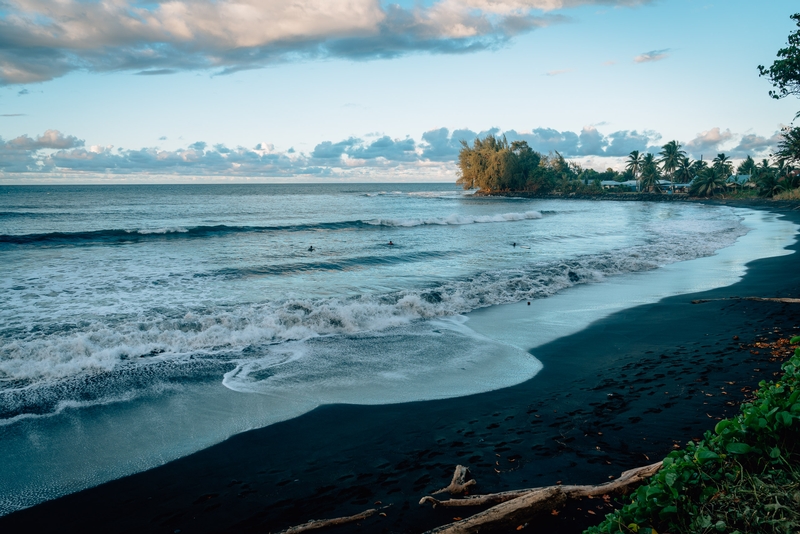 Surfers on a Black Sand Beach