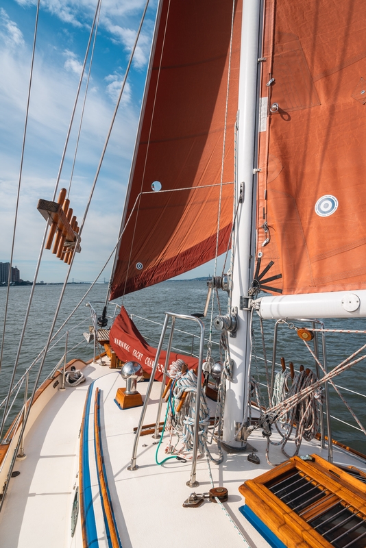 Sailboat With Orange Sails Near Brooklyn Bridge