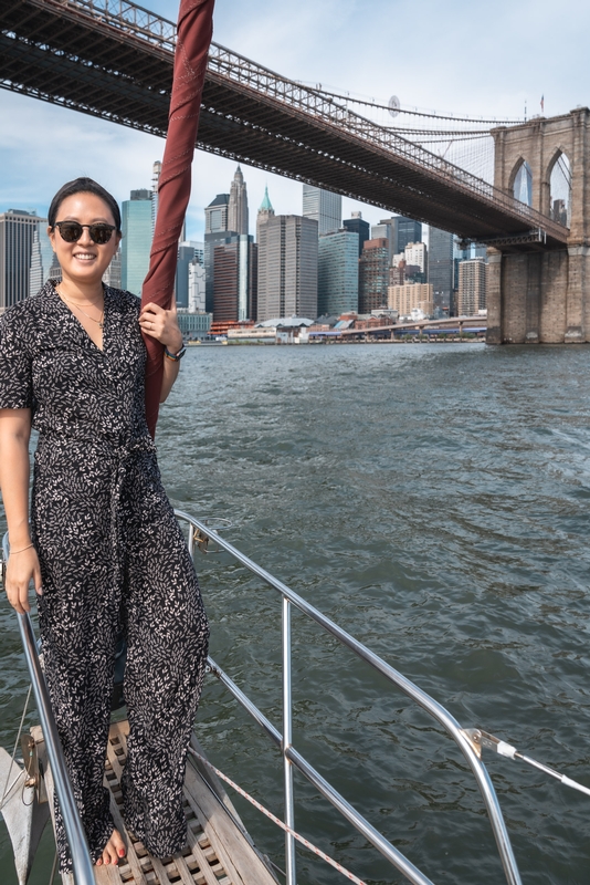 Woman on Boat Under Brooklyn Bridge