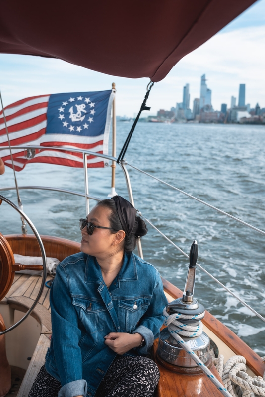 Woman Sailing Toward Manhattan Skyline