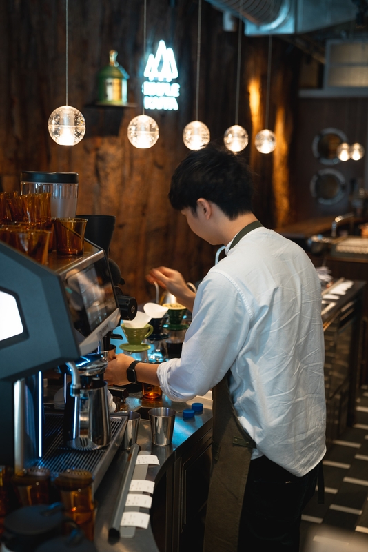 Barista Crafting Espresso Under Pendant Lights