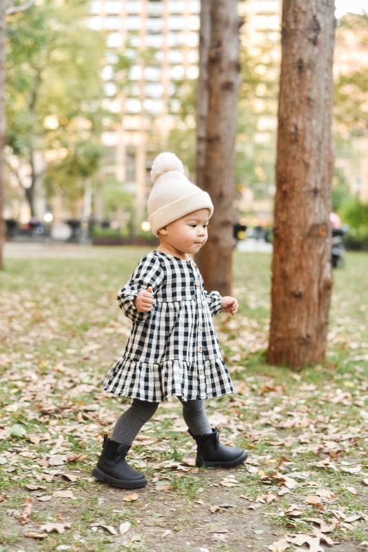 Toddler Walking Through Autumn Leaves