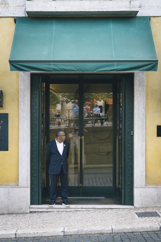 Man In Navy Suit At Storefront Entrance