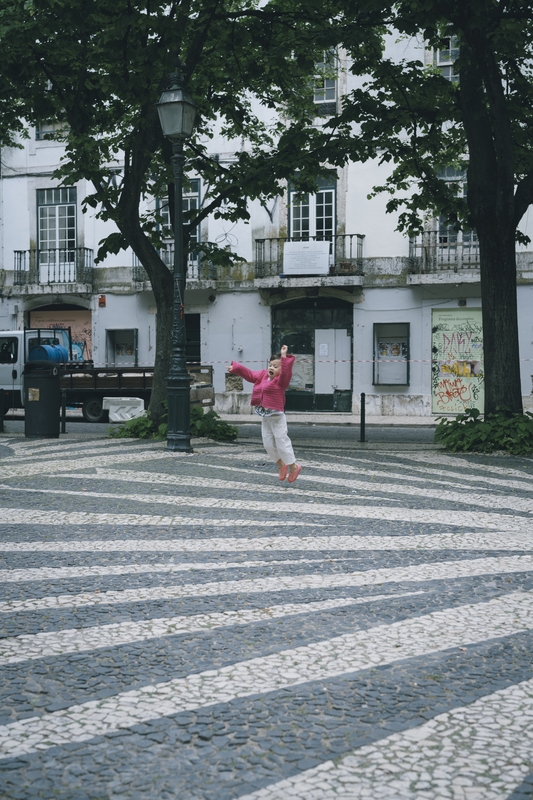 Lulu Running Across Lisbon's Striped Square